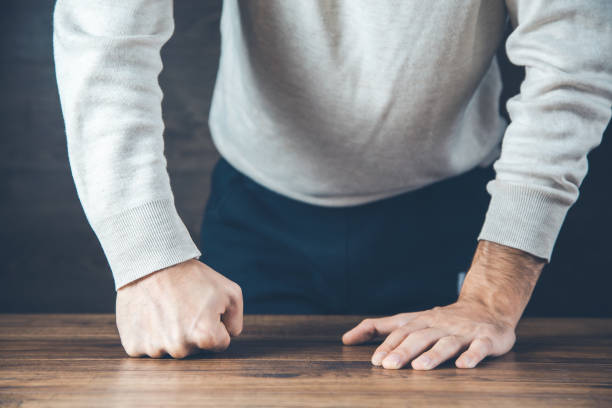istock angry man fists on the desk background 1200488268