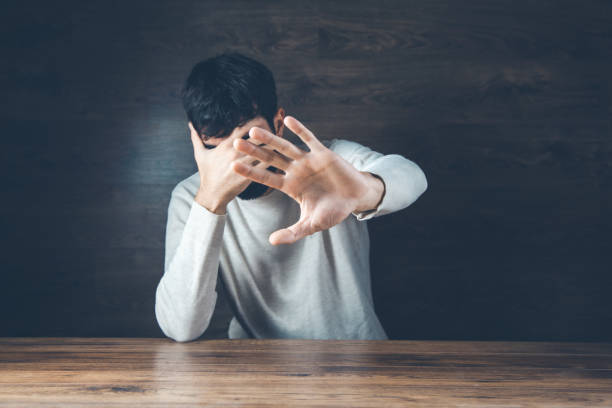 istock sad man hand on head on dark background 1200488275