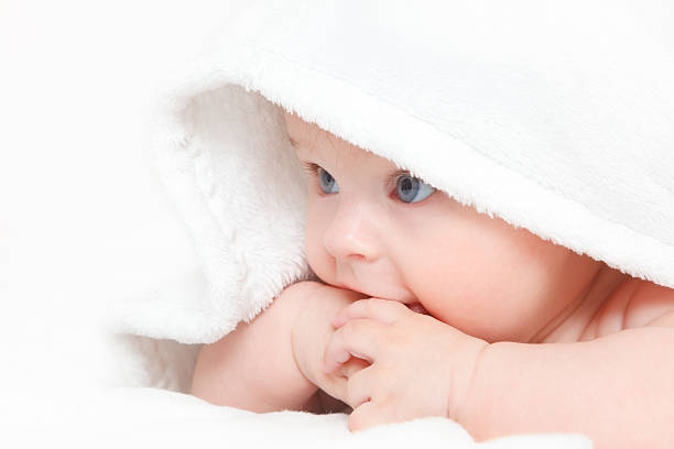 istock Cute baby peeking out from under a white blanket 120049059
