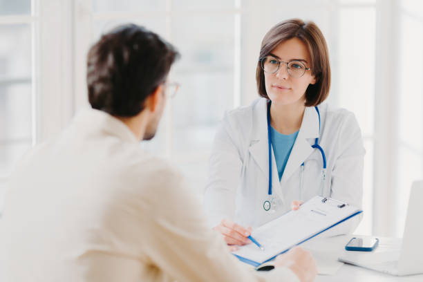 istock Female general practitioner explains which prescribed medicine patient should buy, gives medical visit consultation. Male clinic visitor tells about health complaints to therapist. Healthcare concept 1200492726