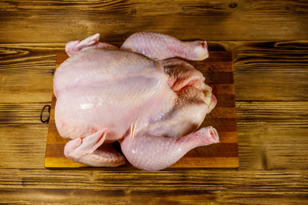 istock Raw whole chicken on a wooden table. Top view 1200493457