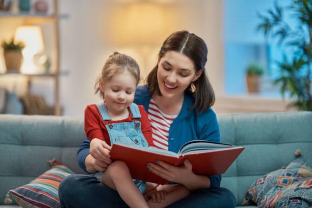 istock mother reading a book to daughters 1200495885