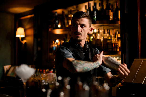 confident and brutal male bartender posing with shaker - men elegance cocktail cool imagens e fotografias de stock