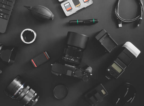 istock top view of work space photographer with digital camera, flash, cleaning kit, memory card, tripod and camera accessory on black table background 1200499378