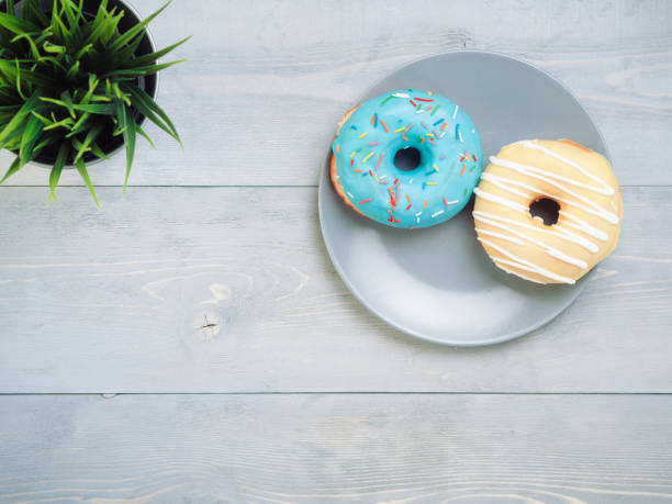 istock donuts on gray wooden background , copy space, top view 1200499705