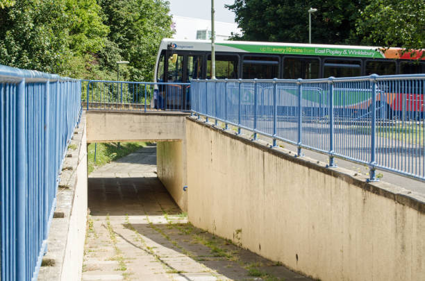 Pedestrian path under bus route, Basingstoke Basingstoke, UK - July 23, 2019:  Pedestrian footpath passing underneath a main road with a bus travelling overhead.  Sunny summer day in the Winklebury district of Basingstoke, Hampshire. basingstoke photos stock pictures, royalty-free photos & images