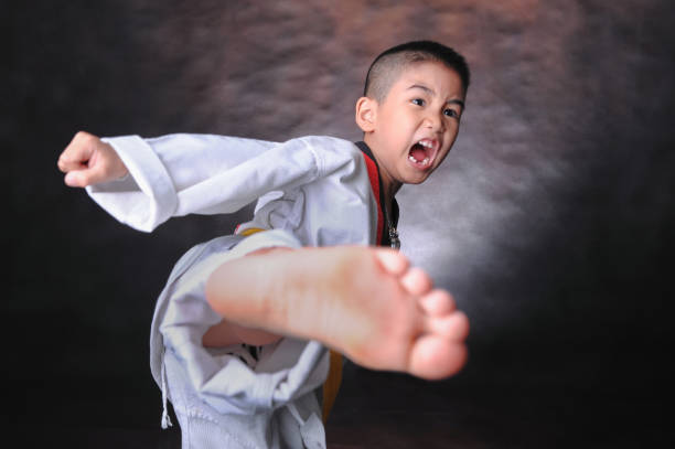 verticale de jeune garçon faisant des mouvements de karaté - child sport karate education photos et images de collection