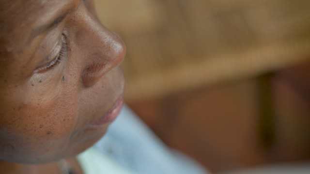 High angle profile view of an elderly senior black woman sitting quietly