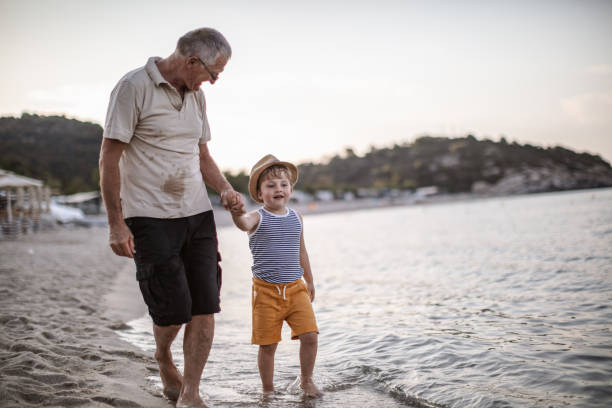 istock Grandfather with grandson walking at the beach 1200520402