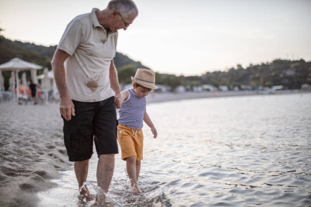 istock Grandfather with grandson walking at the beach 1200520588