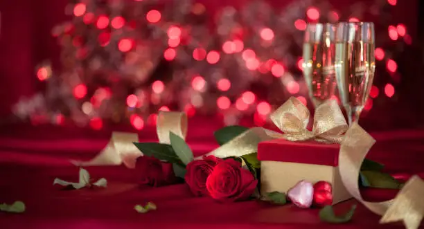 Photo of Valentine's Day Banner with Red Roses and Champagne on a Defocused Lights Background