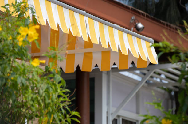 auvent rayé jaune et blanc de la boutique dans le jardin. - sun blind photos et images de collection