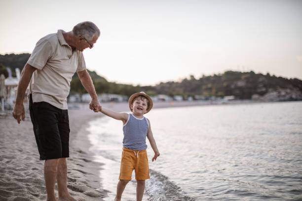 istock Grandfather with grandson walking at the beach 1200521591