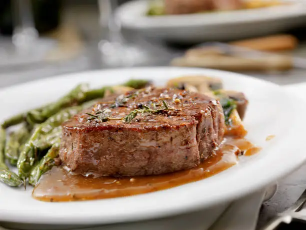 Photo of Medium Rare Fillet Mignon Steak with a Mushroom Sauce, Roasted Green Beans and Mushrooms