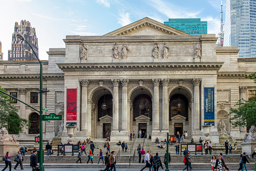 People walking in Fifth Avenue at the entrance of the New York Public Library in Midtown Manhattan, New York City, USA.
