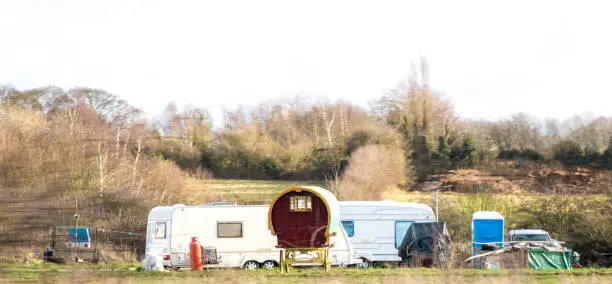 A typical gypsy camp site set up in a random field at the side of a motorway.