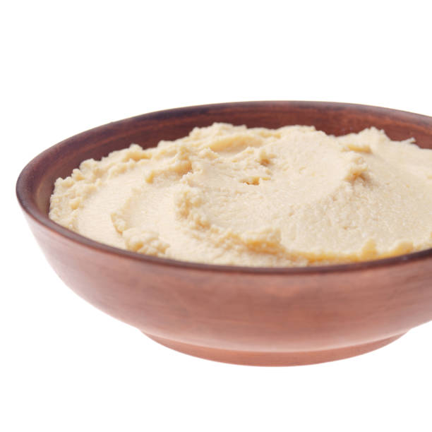 istock Plate with hummus - spread made from cooked, mashed chickpeas blended with tahini, lemon juice, and garlic isolated on white background. Clipping path added 1200526788