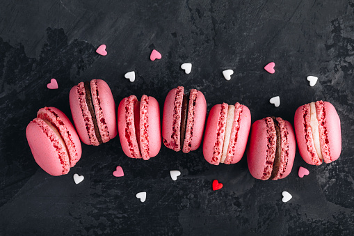 Valentines day pink cake macarons on dark stone background