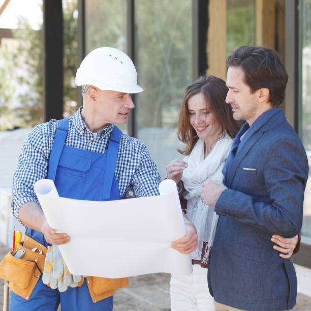 istock Foreman and couple with blueprint 1200529305