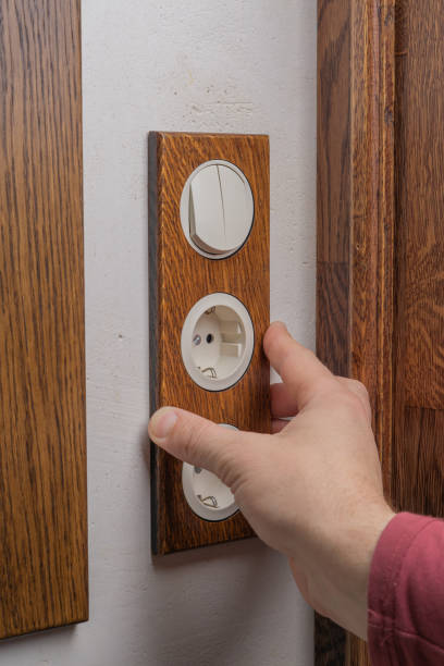 istock Wall socket . The process of installing an electrical outlet. Handcrafted oak wood overlay. 1200529480