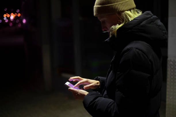 istock Young woman scrolling smartphone at night 1200531025