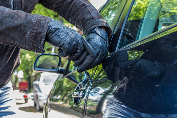 eine person versucht, das schloss eines autos mit einem schraubendreher zu brechen - car stealing thief car thief stock-fotos und bilder