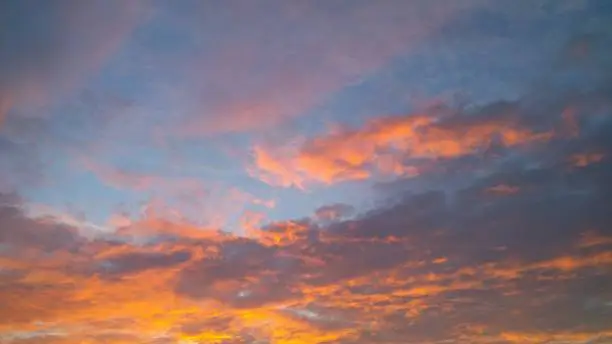 clouds split by sunset on blue sky