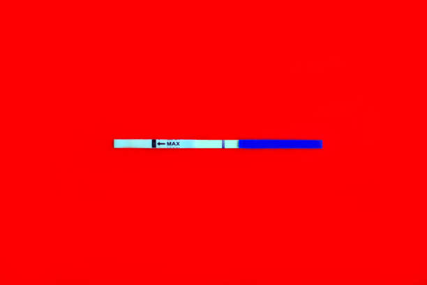 istock The test a strip on pregnancy with negative result on the middle on a red background. 1200533590