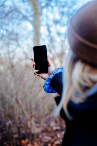 istock Young woman using a smartphone outdoors 1200536020