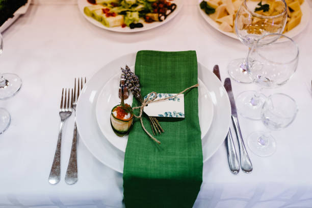 istock Serving guests, setting table. Two plates, silverware cutlery, green linen napkin with lavender. Wedding table decoration. flat lay. top view. Close up. 1200536627