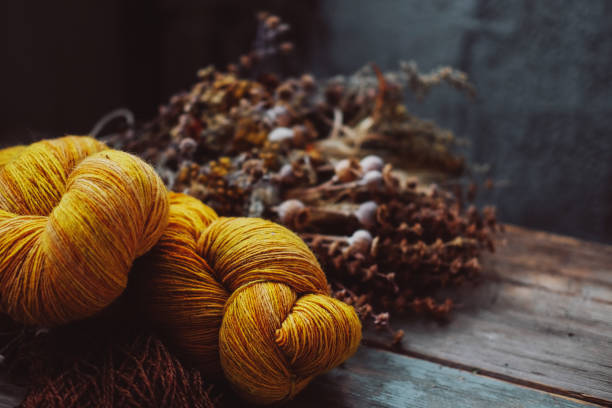 istock Bright yellow wool yarn skeins in rustic background. Hobby and craftsmanship concept. 1200538110