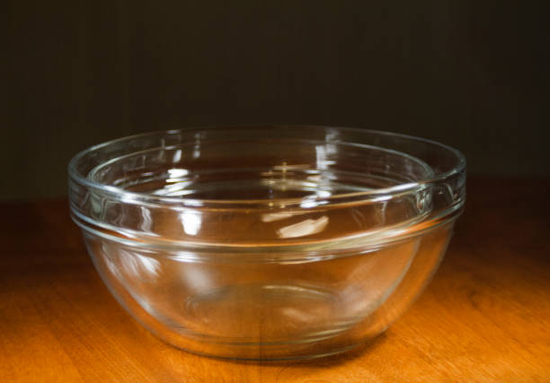 istock Glass bowls nested or stacked on a wooden surface with dark background 1200542004