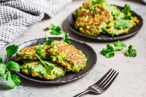 Green broccoli and pea pancakes. Healthy vegan food concept. Green broccoli and pea pancakes (cutlets) on black plate. Healthy vegan food concept. fritter photos stock pictures, royalty-free photos & images