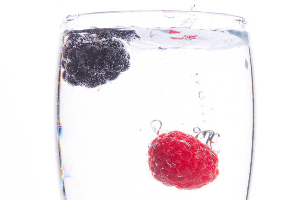 Refreshing image of a a raspberry and a blackberry in a water splash