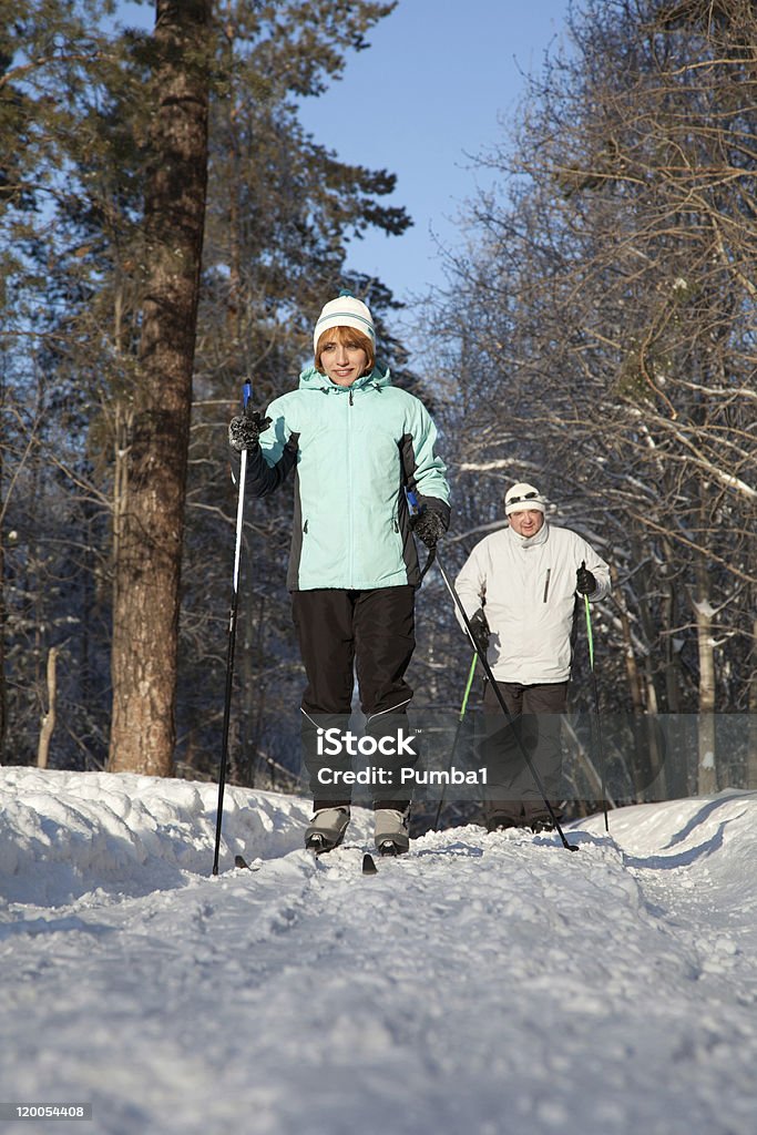 Homem e mulher em pé na floresta de esqui no inverno - Foto de stock de Adulto royalty-free