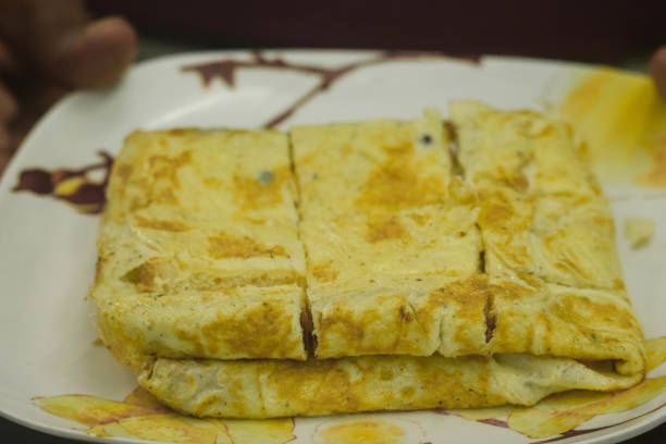 Selective Focus On Bread Wrapped In  Omelette or Omelet Made Of Fried Beaten Eggs Served in Plate