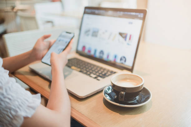 istock A woman sitting using a laptop and smartphone while eating coffee 1200548345