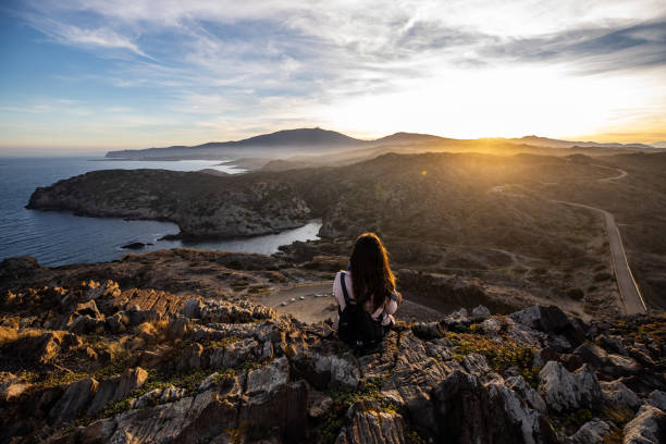 istock Beautiful woman standing on a cliff during sunset at Cap de Creus, in Spain with copy space 1200548507