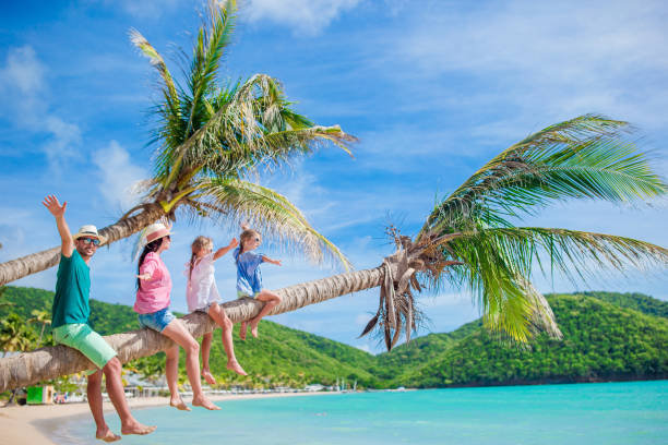 istock Happy family on the beach on palm tree during summer vacation 1200552596
