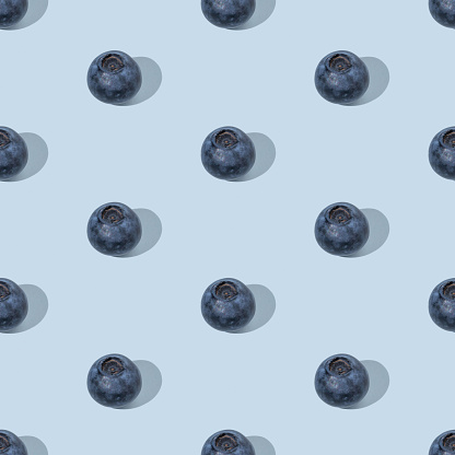 Colorful summer seamless pattern made of blueberries on blue background