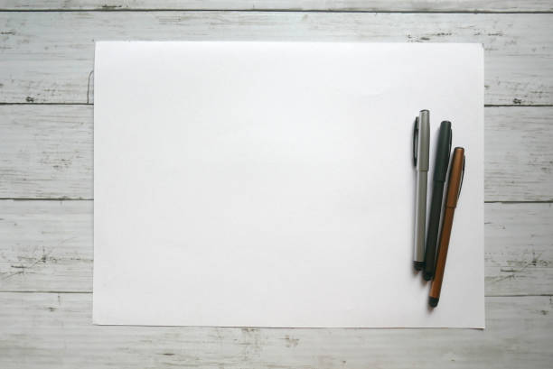 istock three pen on white paper background lay on white wooden background. Copy paste for text, logo and etc. 1200559078