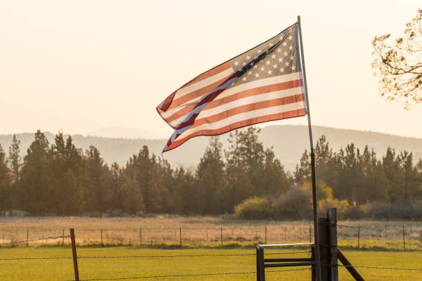 Sunset light passes through a waving U.S. flag near Terrebonne, Oregon, United States