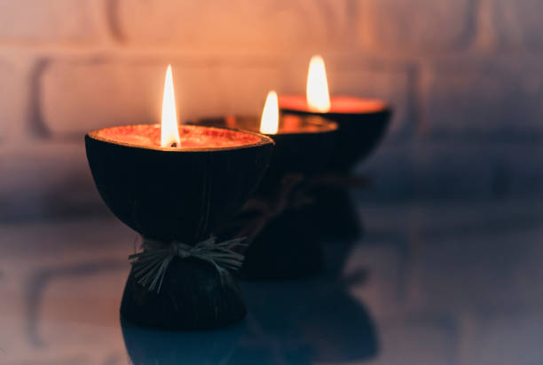 istock Burning spa aroma candles in coconut shell on a glass white table, cozy home interior 1200560815