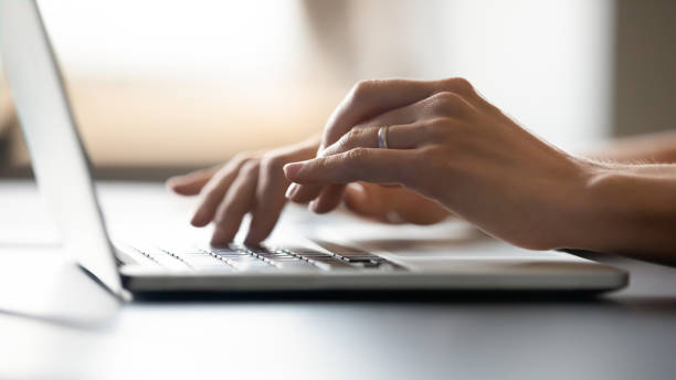 istock Close up of woman typing message on keyboard 1200561507