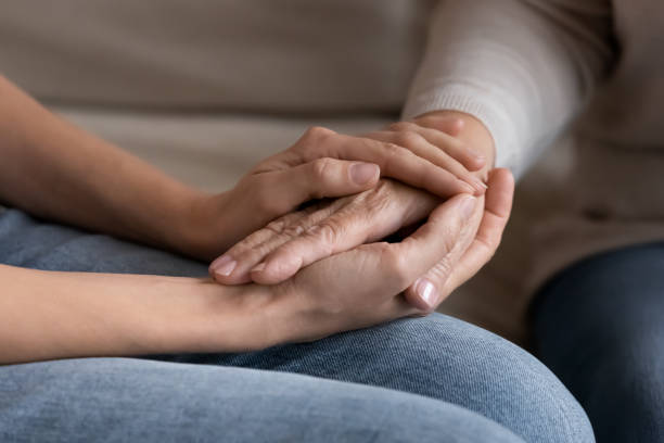 istock Supportive adult daughter hold senior mom hands 1200561573