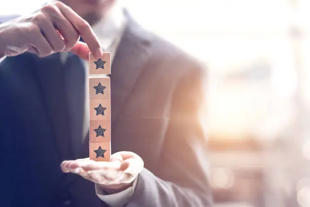 Photo of Businessman holding five star symbol to increase rating of company