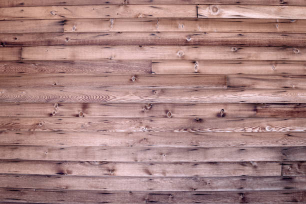 A full frame rustic natural wood grain board barn wall background with a rough knotted wood texture.