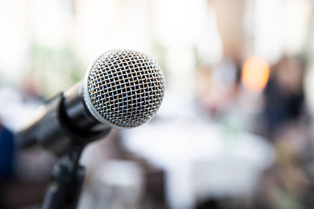 istock Microphone on blurred of speech in seminar room or speaking conference 1200568470