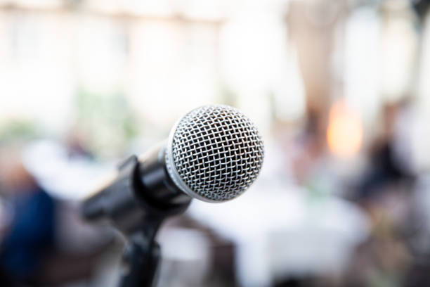 istock Microphone on blurred of speech in seminar room or speaking conference 1200569065