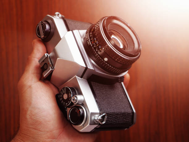 Hand holding a vintage SLR analog film camera